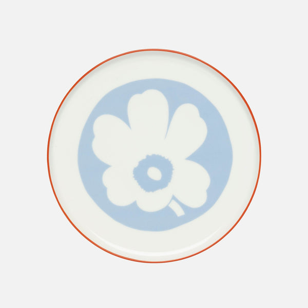 Decorative plate with a white floral design on a light blue circle, set against a white background.