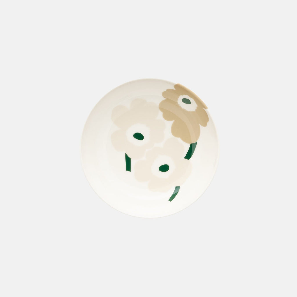 Round beige object with a brown flower-like design on a white background