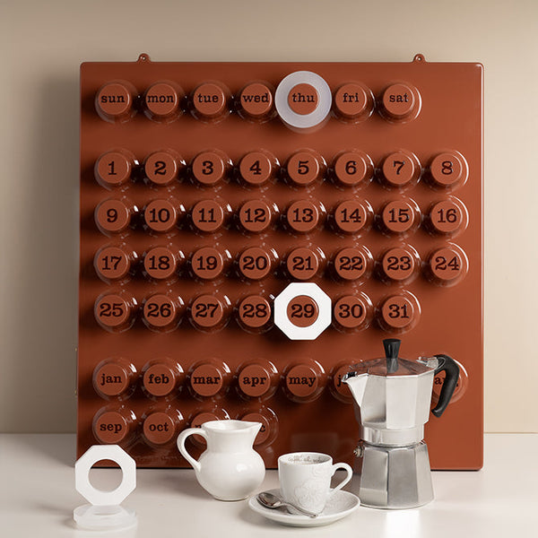 Calendar with coffee-themed design featuring a pitcher, cup, and saucer on a beige background