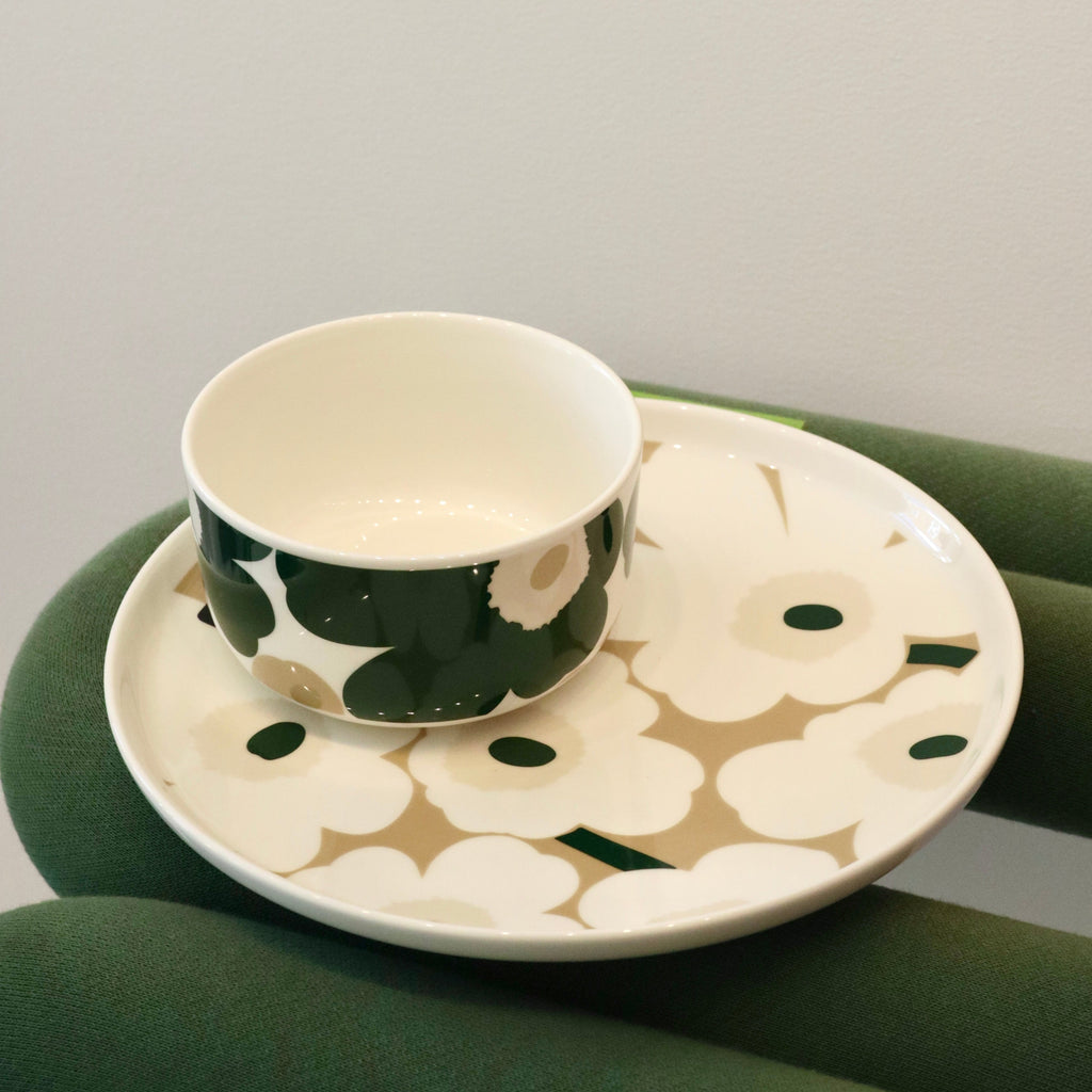 Ceramic cup and saucer with floral design on a green surface