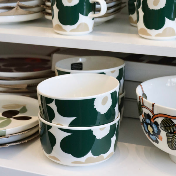 Set of green and white floral-patterned ceramic dishes on a shelf.
