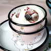 Two-tiered dessert with whipped cream and berries in a pink container with cartoon characters on a light background.